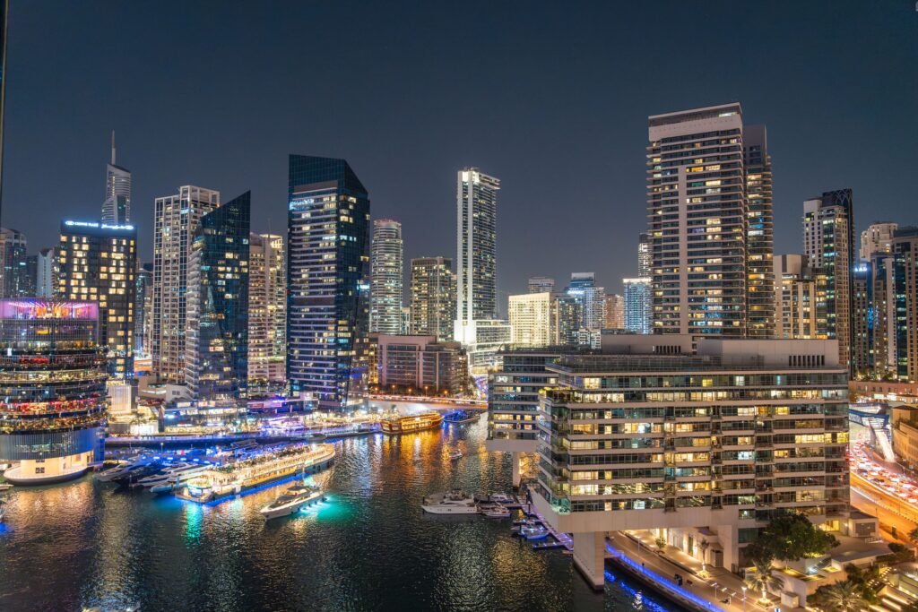 Dubai Marina skyline at night with waterfront towers and yachts, highlighting Bay Area investors Dubai property opportunities.